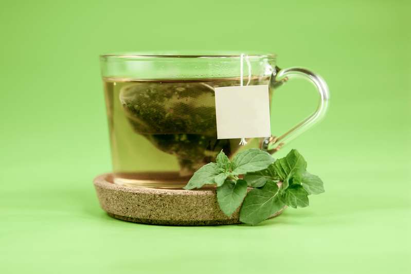Fresh herbal ingredients like turmeric, ginger, and mint arranged on a wooden table